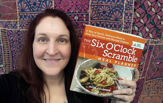 Carma holding her copy of The Six O'Clock Scramble by Aviva Goldfarb