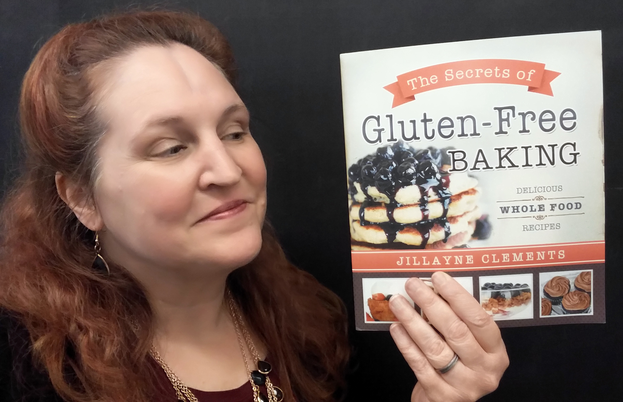 Carma Spence holding a copy of The Secrets of Gluten-Free Baking by Jillayne Clements